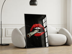 Framed artwork with red lips and a cigar on a white armchair in a room.