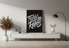 Modern interior with a black frame displaying 'Fuck the Rules' on a white wall.