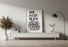 Modern living room with a 'Think Outside the Box' poster on a white wall.