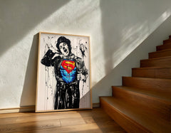 Framed artwork of a character wearing a Superman costume on a wall next to wooden stairs.