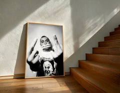 Framed black and white artwork on a wall with wooden stairs in the background