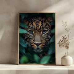 Framed artwork of a leopard surrounded by leaves on a wall with a vase on a shelf.