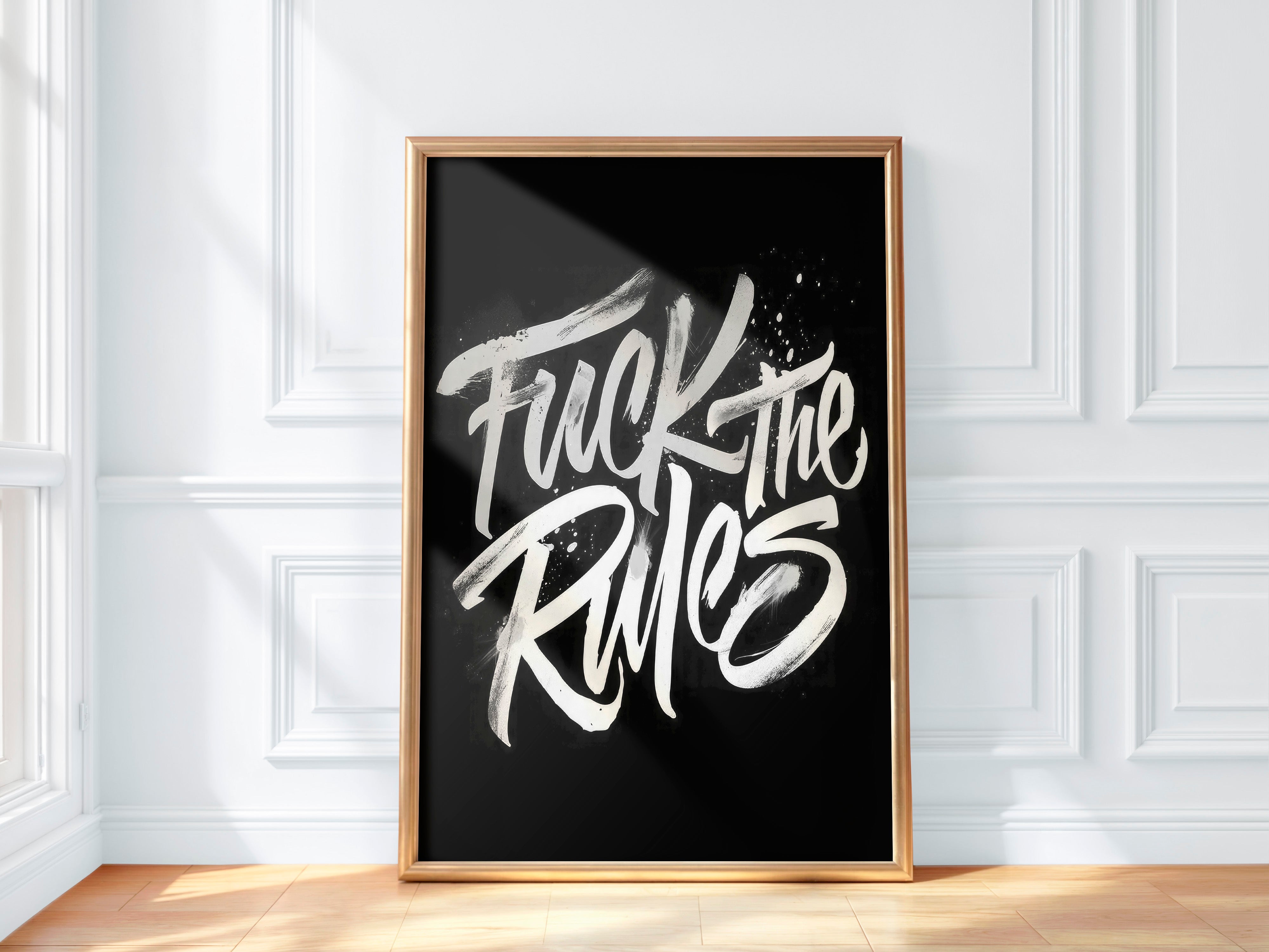 Framed poster with 'Fuck the Rules' text on a black background in a room with white walls and wooden floor.
