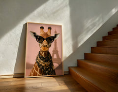 Framed picture of a giraffe wearing sunglasses with the Eiffel Tower in the background, leaning against a wall next to wooden stairs.