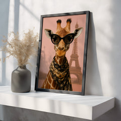 Framed artwork of a giraffe wearing sunglasses with the Eiffel Tower in the background on a white shelf.