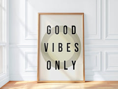 Framed artwork with 'Good Vibes Only' text on a white wall.
