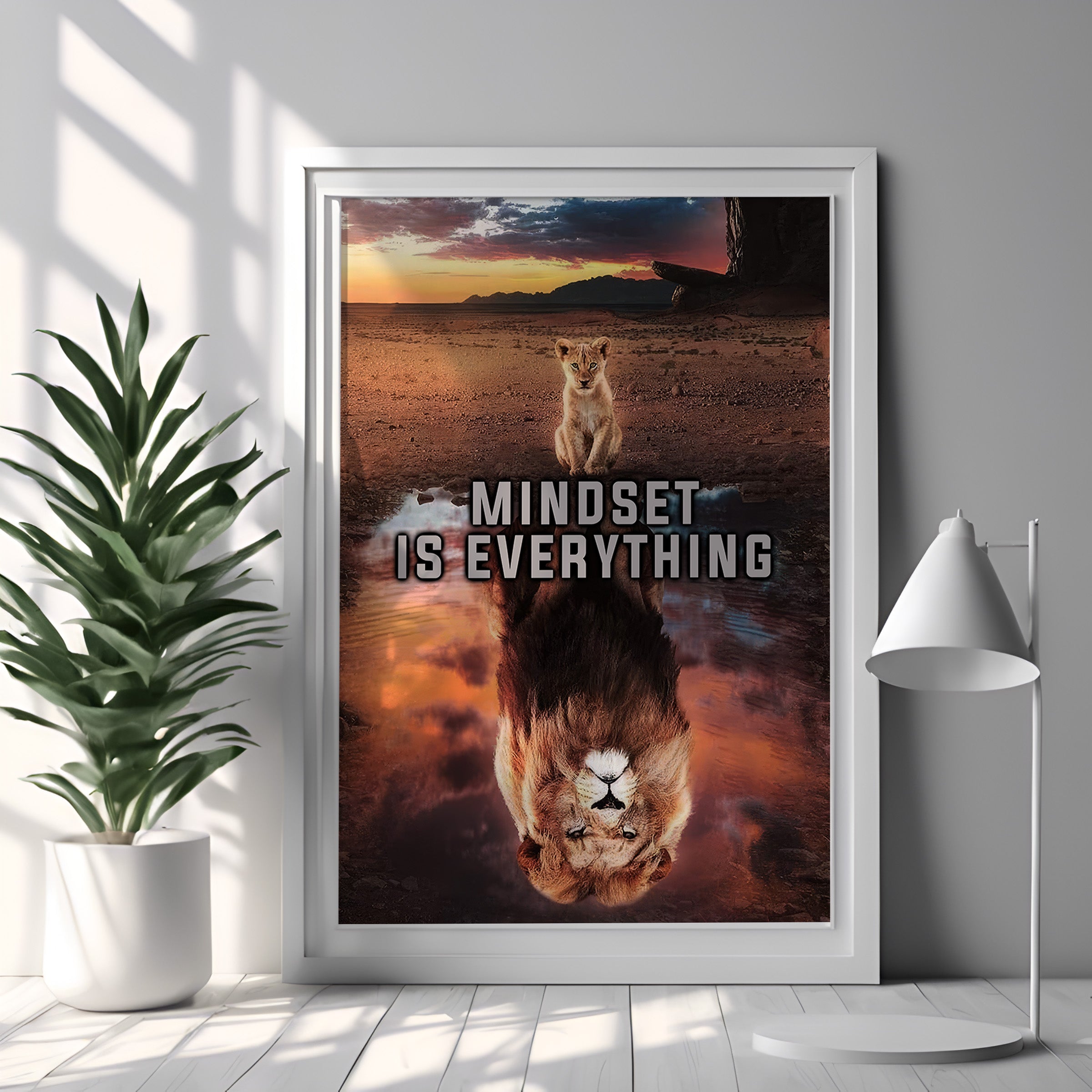 Framed poster with a lion and reflection, featuring the quote 'Mindset is Everything', in a room with a plant and lamp.
