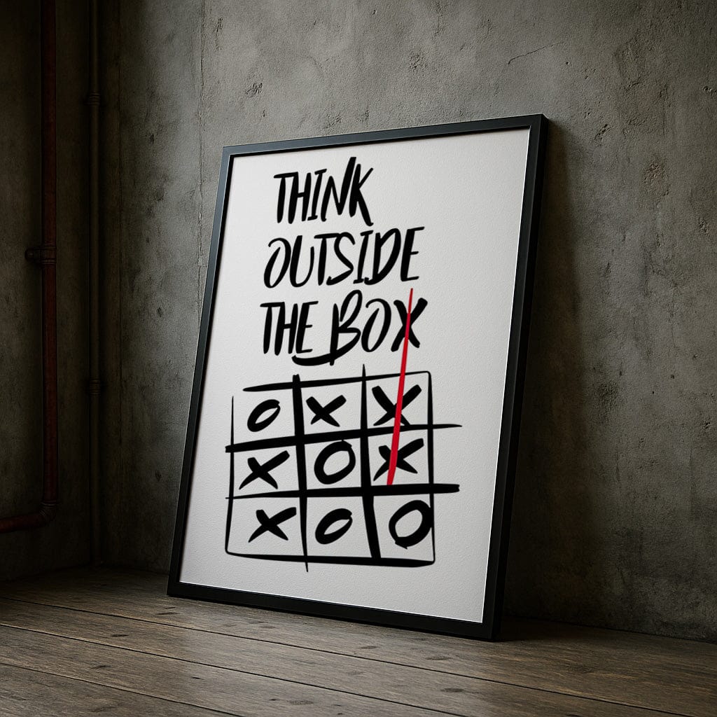 Framed poster with 'Think Outside The Box' quote and tic-tac-toe game on a concrete wall.