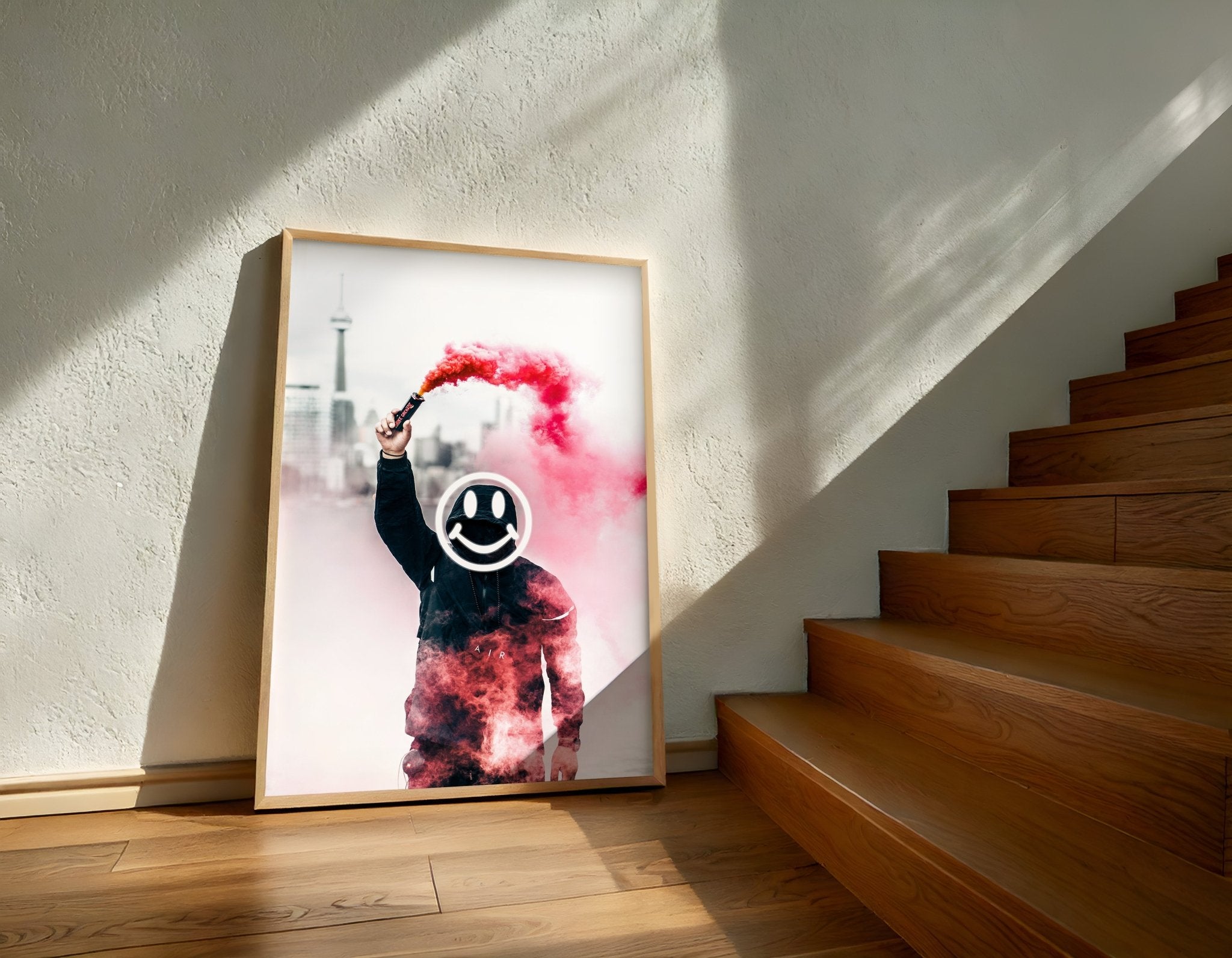Framed artwork with a person holding a colorful smoke device against a white background, placed on a wooden staircase.