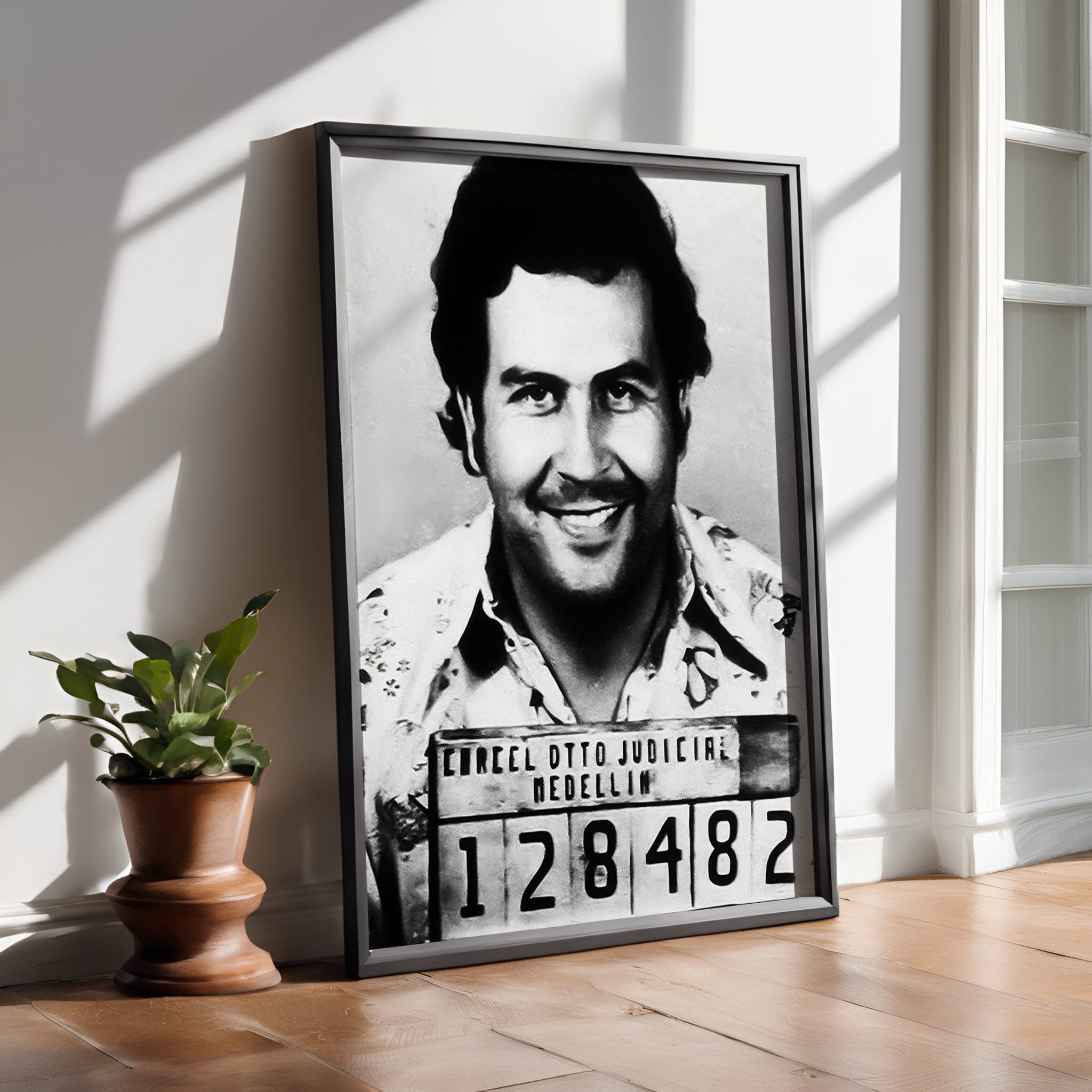 Framed black and white portrait of a man with a mugshot-style label on a wooden floor.