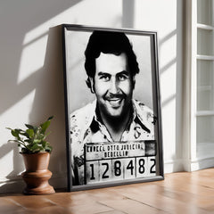 Framed black and white portrait of a man with a mugshot-style label on a wooden floor.