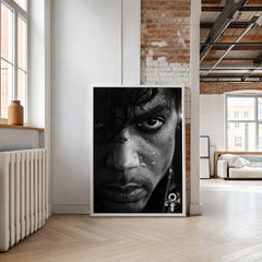 Poster of a man's face with a serious expression in a modern room with brick wall and large windows.