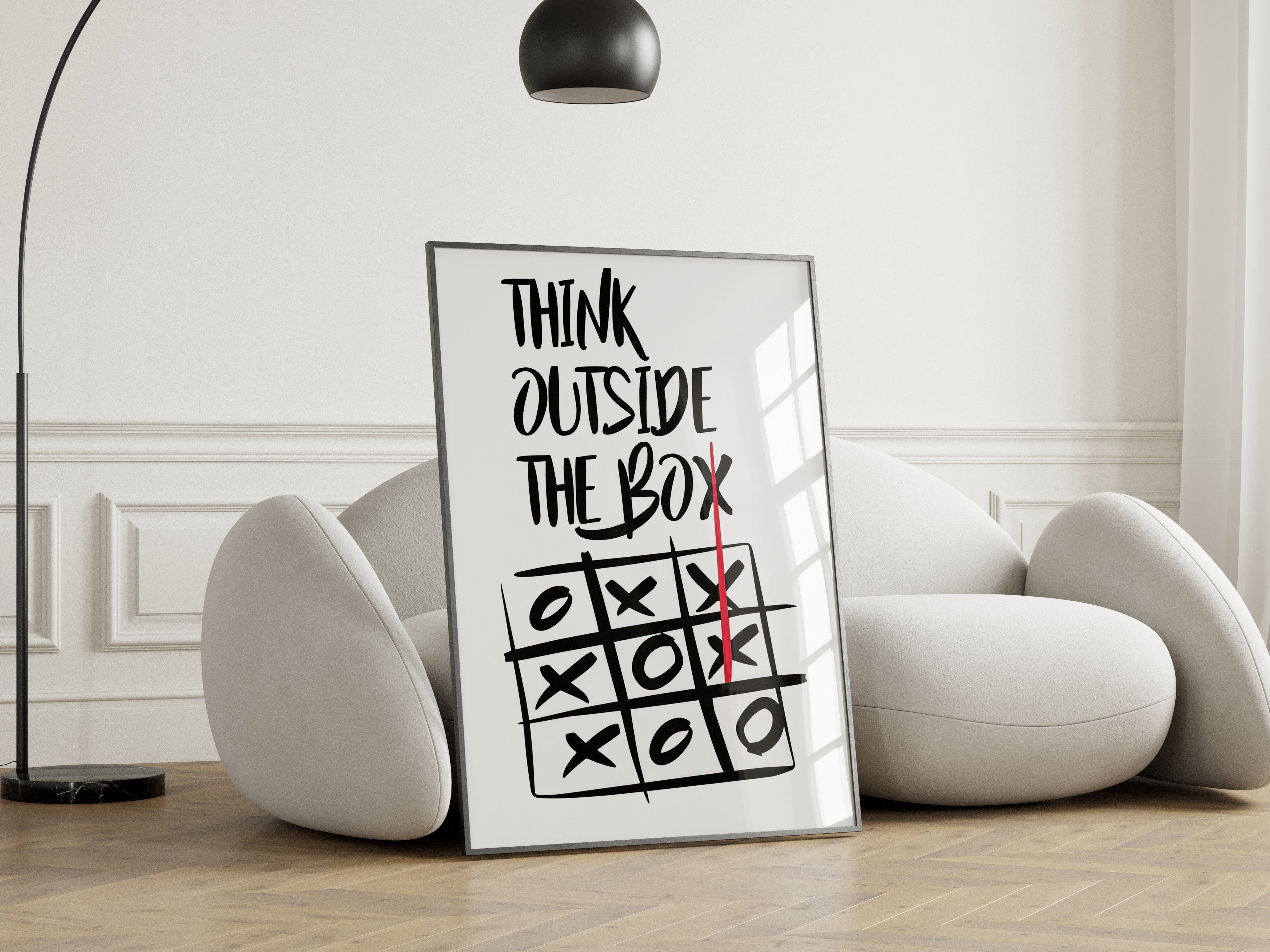 Framed poster with 'Think Outside The Box' quote and tic-tac-toe game in a modern living room.