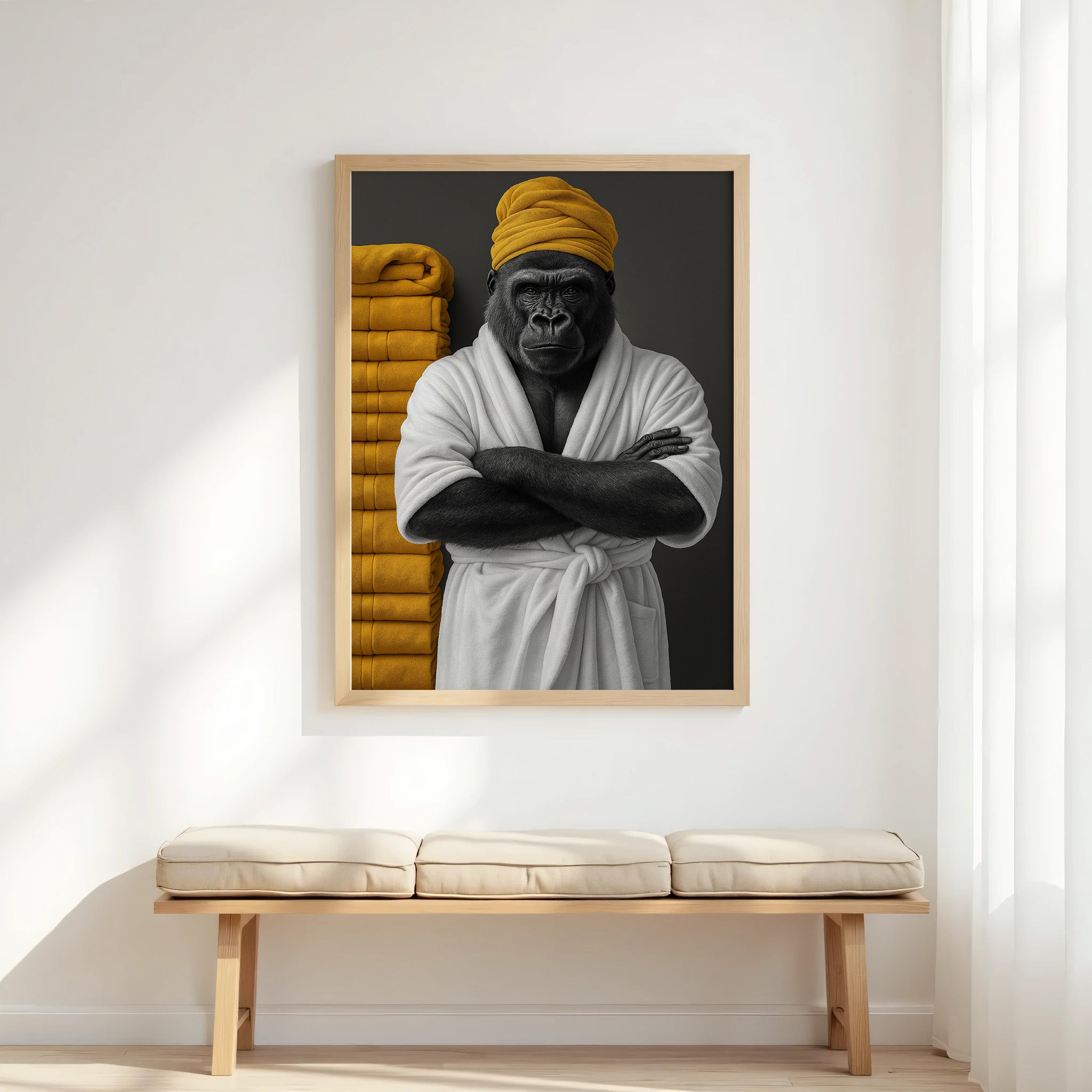 Framed artwork of a gorilla in a robe with a yellow towel on a white wall above a wooden bench.