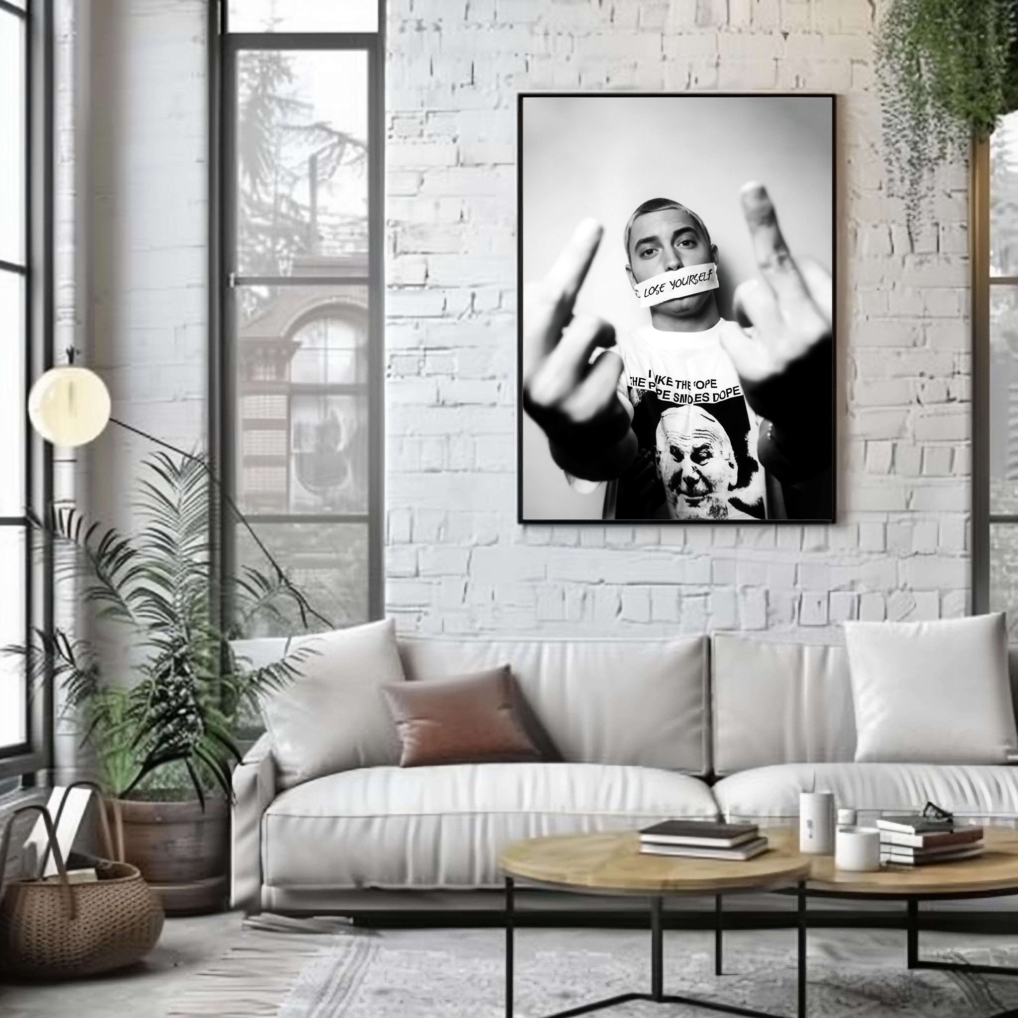 Living room with a white sofa, coffee table, and framed poster on a brick wall.