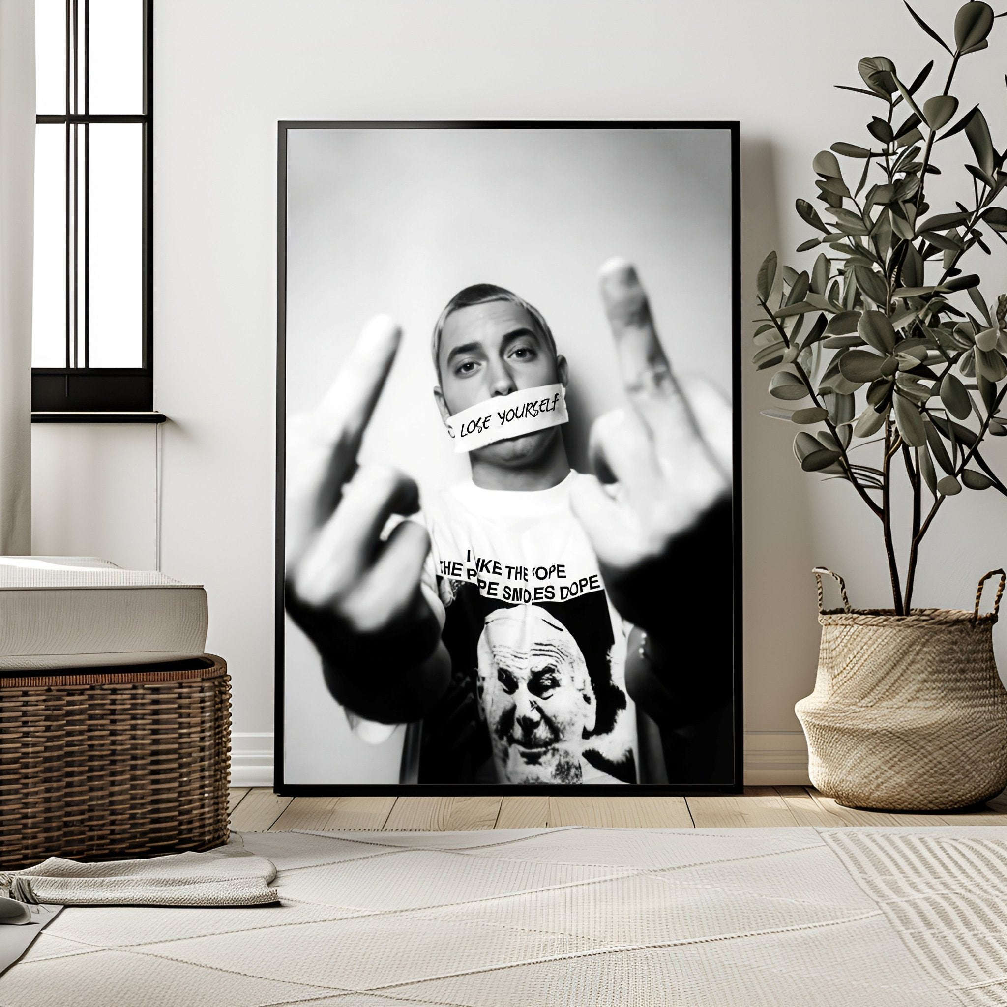 Framed poster of a person with a message on a wall in a room with decor elements.