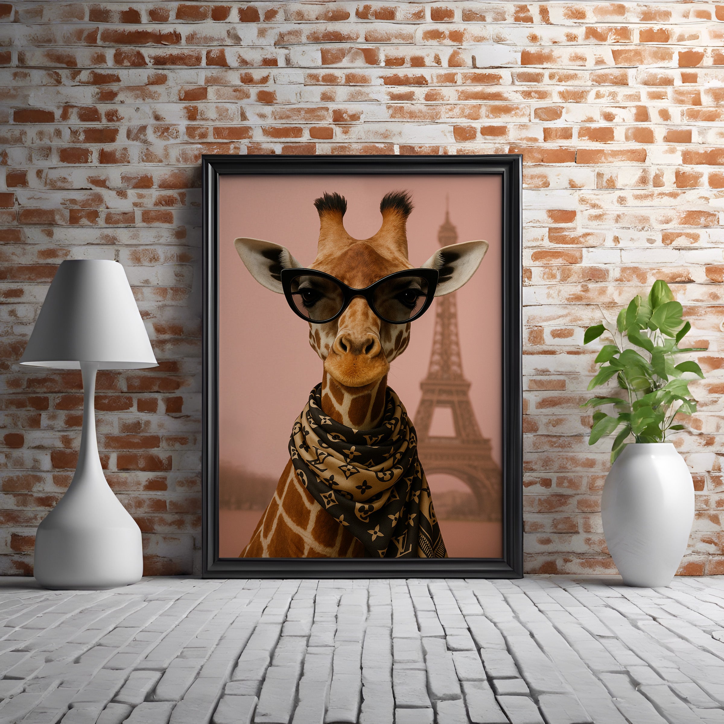 Framed artwork of a giraffe wearing sunglasses with the Eiffel Tower in the background, on a brick wall.