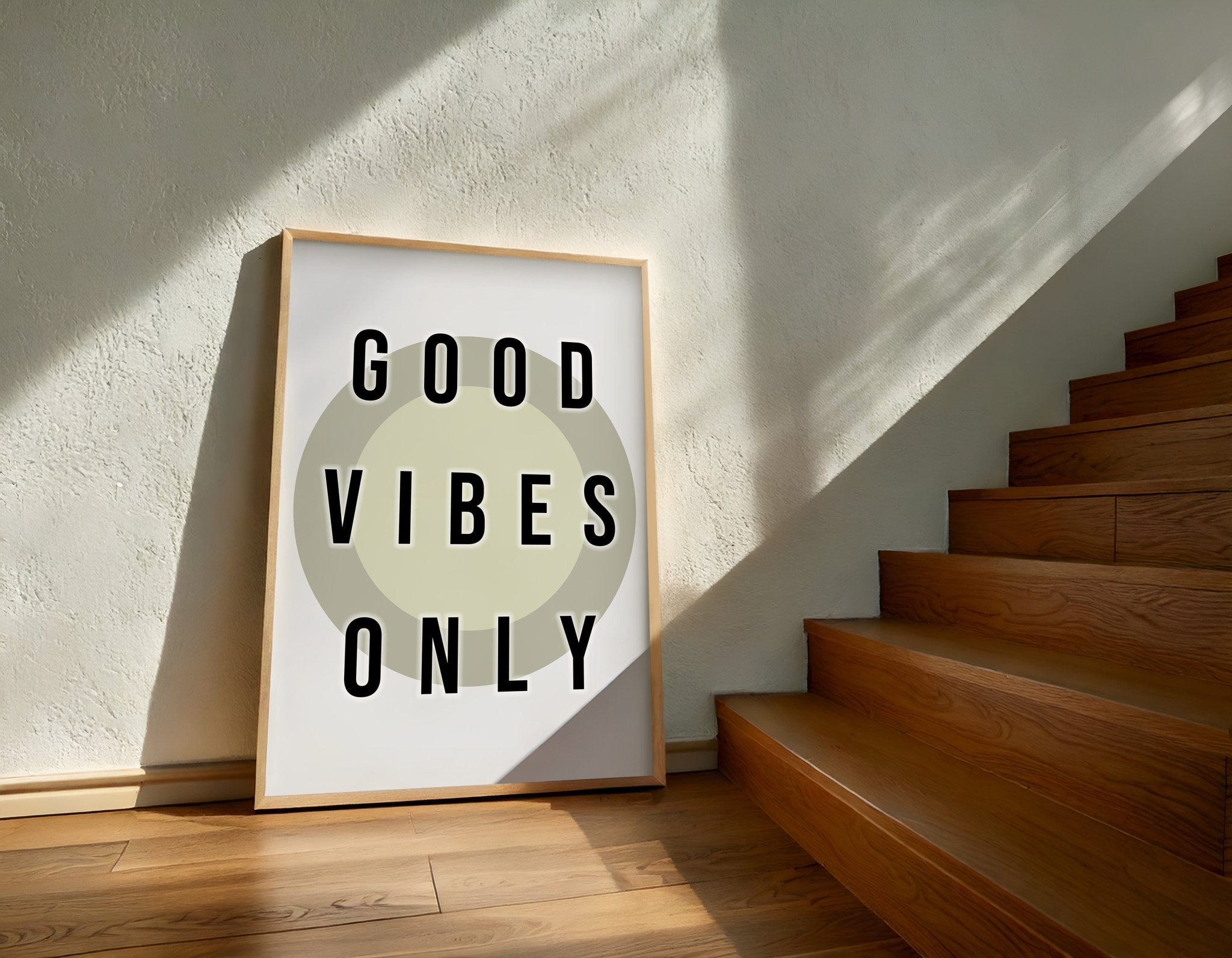Framed 'Good Vibes Only' poster on a wall next to wooden stairs