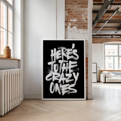 Poster with 'Here's to the Crazy Ones' text in a modern living room.